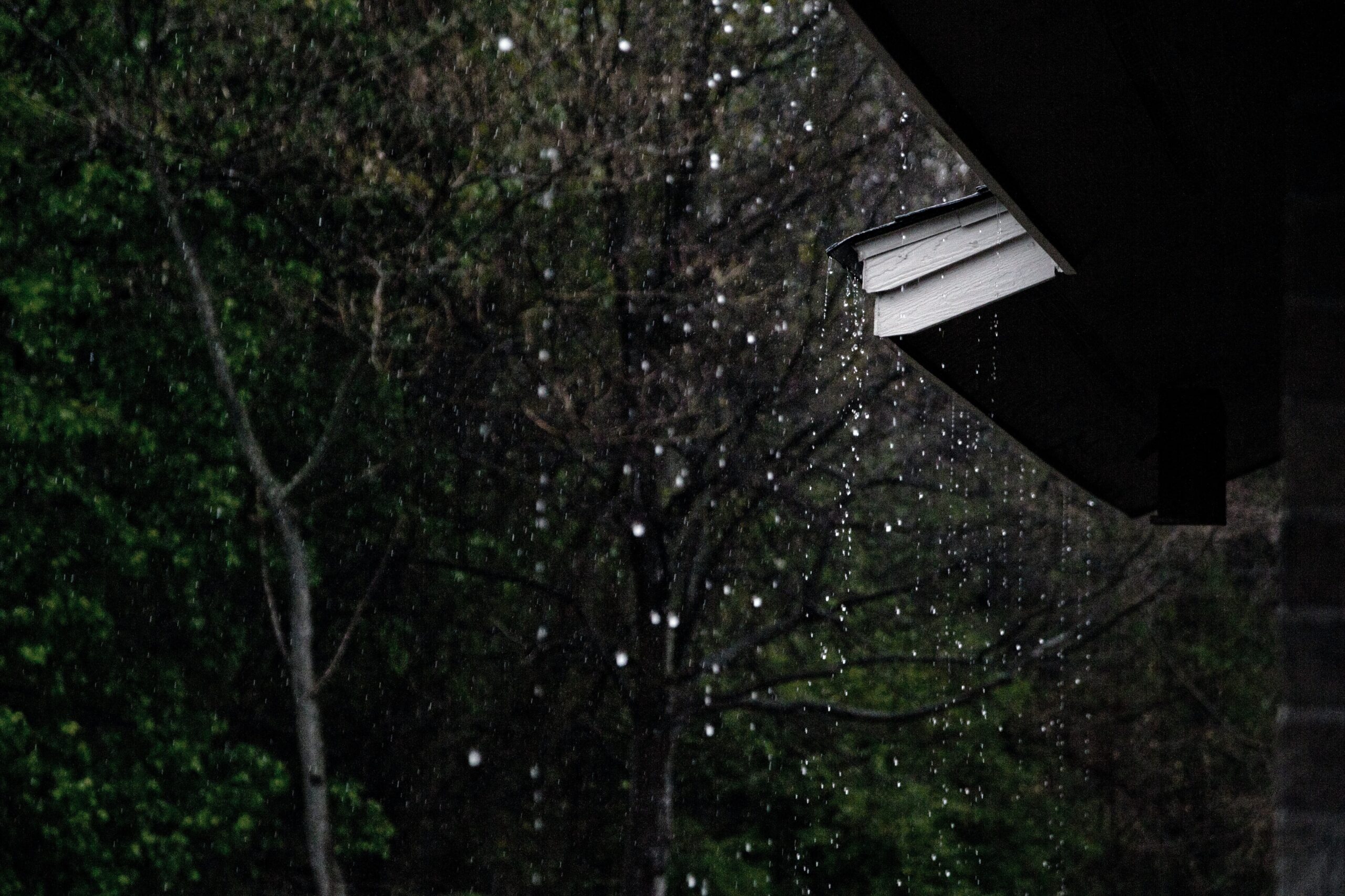 Rain Coming Down Next to an Overhang of a Roof