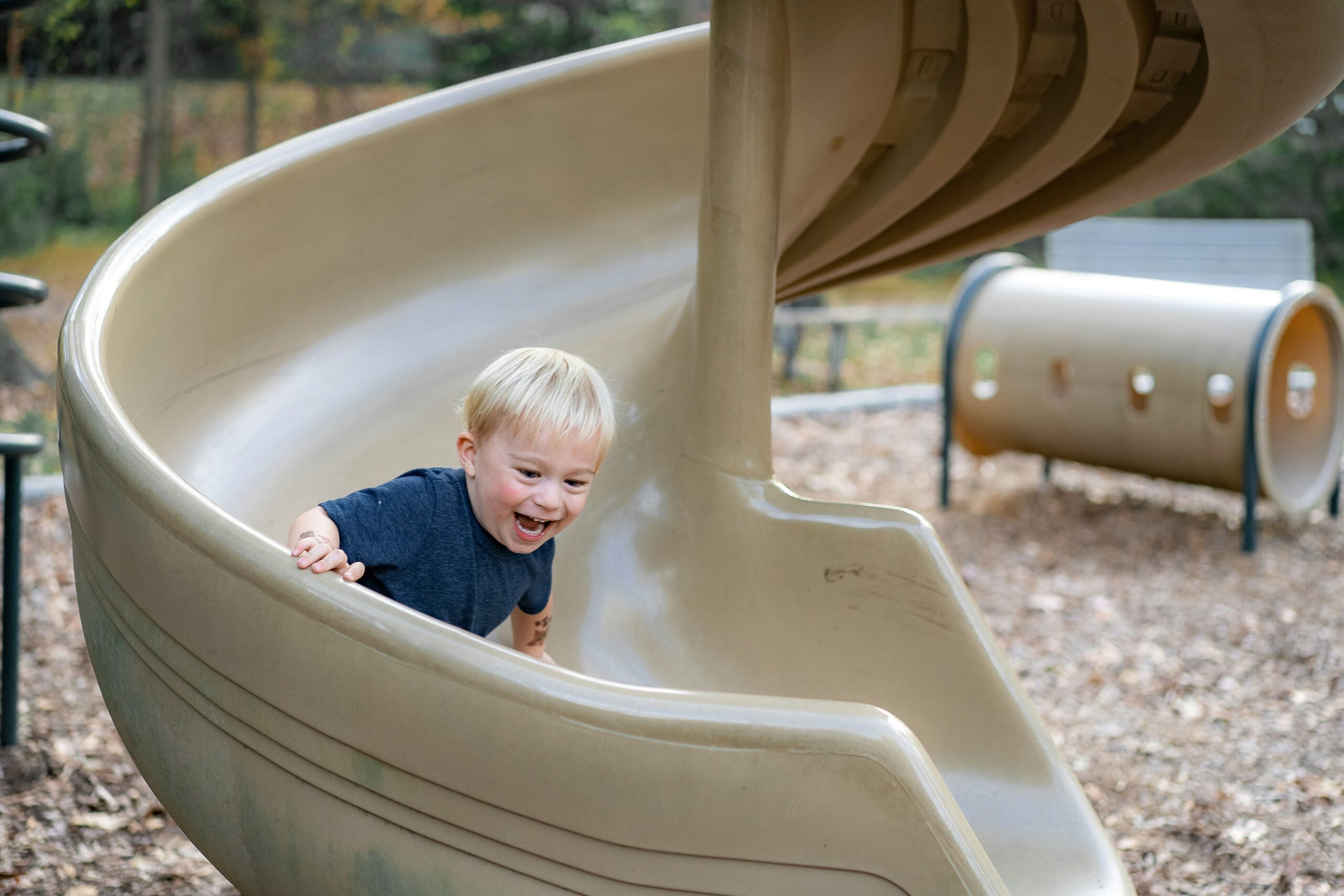 Happy child sliding down sliding board.